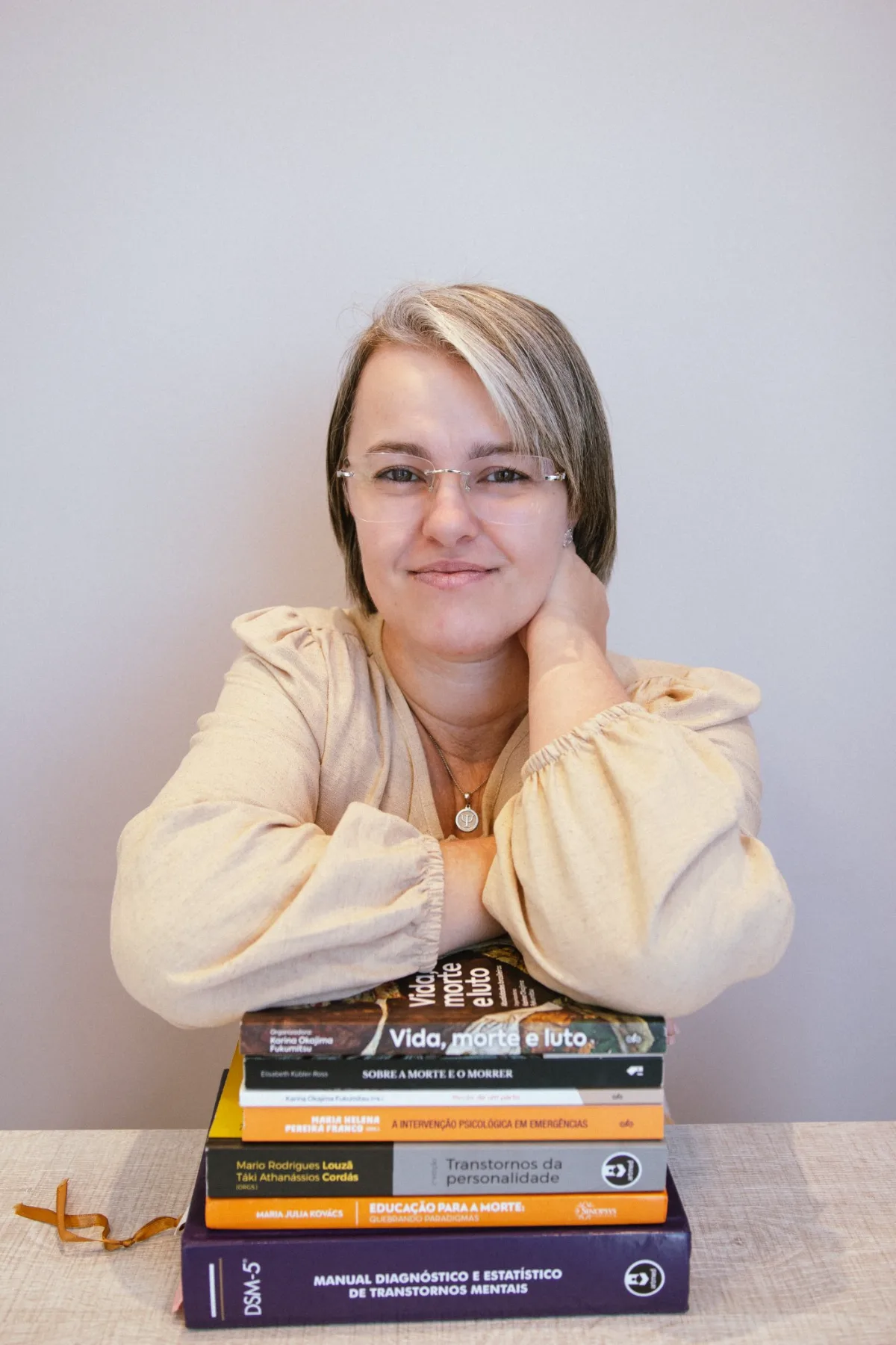 Fransielli Geviewski, psicóloga, apoiada em livros de psicologia sobre luto e trauma